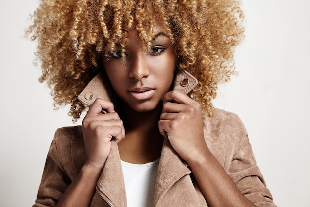 Foto gratuita la mujer negra lleva el pelo rizado de la chaqueta beige
