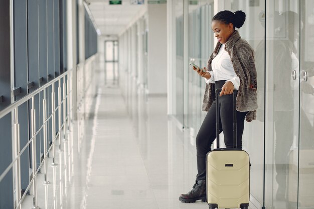 Mujer negra con maleta en el aeropuerto