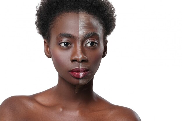 Mujer negra con media cara en maquillaje, concepto de belleza