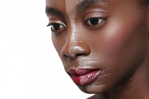 Mujer negra con media cara en maquillaje, concepto de belleza