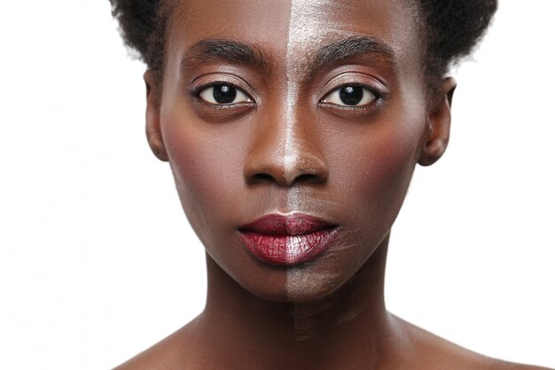 Mujer negra con media cara en maquillaje, concepto de belleza