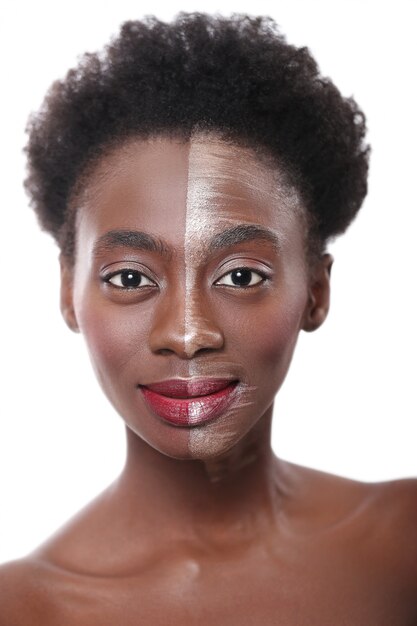 Mujer negra con media cara en maquillaje, concepto de belleza