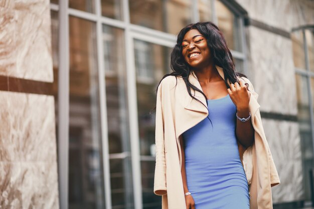 Mujer negra de pie en una ciudad de otoño