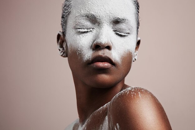 Mujer negra con un polvo blanco cubrió su rostro tratamiento de cosmetología piel dañada por la temperatura fría