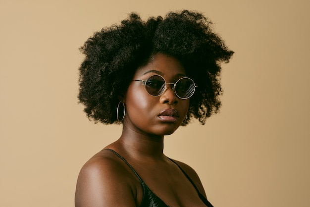 Mujer negra posando con vista lateral de gafas de sol