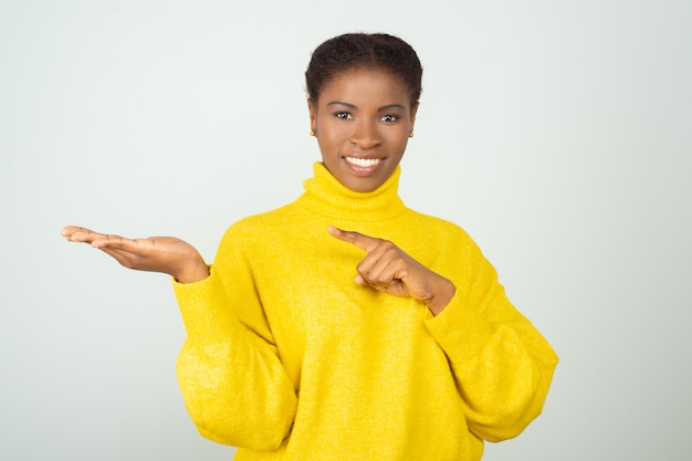 Mujer negra positiva alegre en suéter brillante