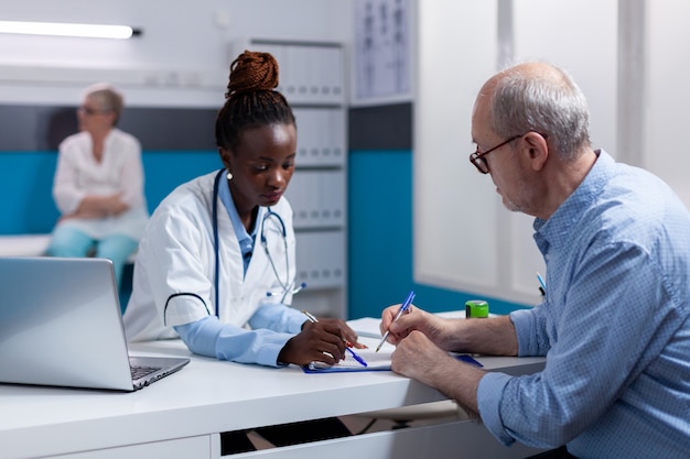 Foto gratuita mujer negra con profesión médica mirando documentos