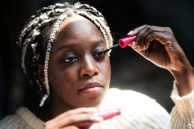 Mujer negra que aplica el rimel