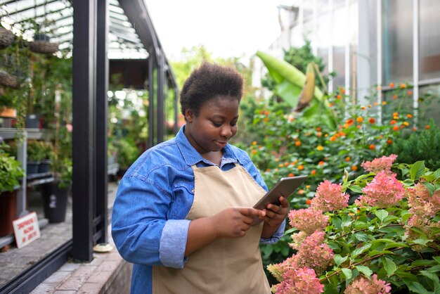 Mujer negra que ejecuta una vista lateral del negocio de las flores