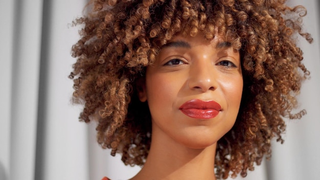 Mujer negra de raza mixta con cabello rizado y maquillaje cálido natural