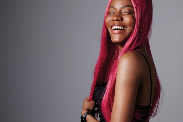 Mujer negra riendo feliz usa peluca rosa