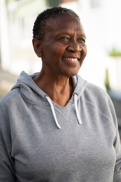 Mujer negra sonriente de tiro medio al aire libre