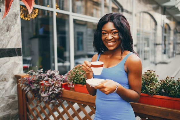 Mujer negra tomando un café en un café