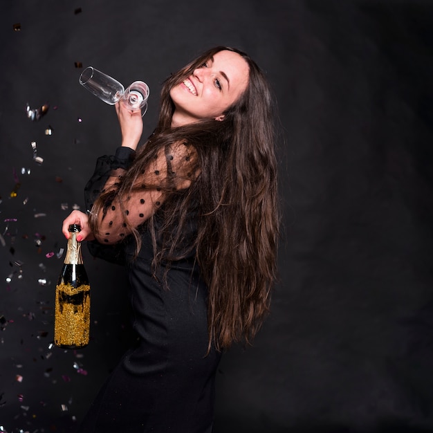 Foto gratuita mujer en negro con botella de champagne y copas