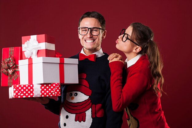 Mujer nerd besando a su novio en Navidad