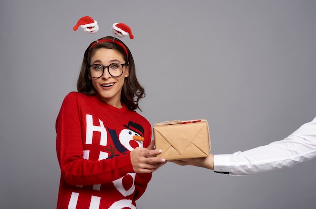 Mujer nerd con regalo de Navidad y cara divertida