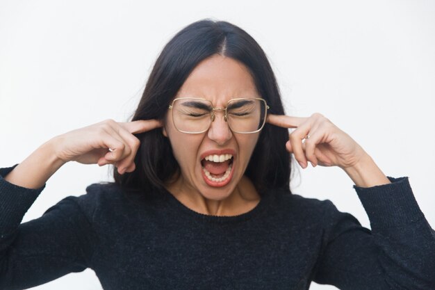 Mujer nerviosa estresada cubriendo las orejas con las manos