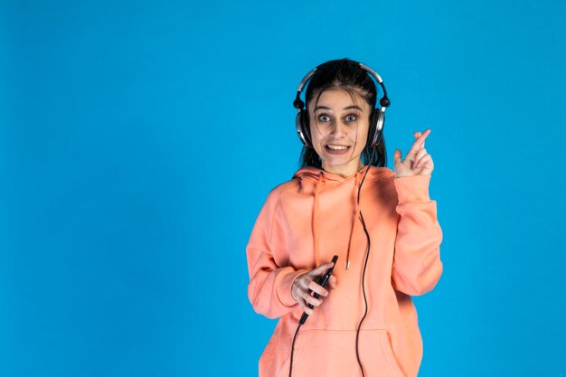 Mujer nerviosa usando auriculares y señalando con el dedo a un lado