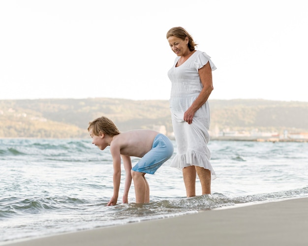 Foto gratuita mujer y nieto en la playa