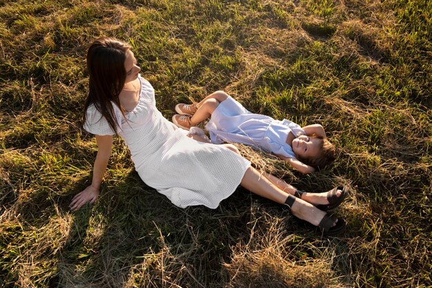 Mujer y niña de alto ángulo en el suelo