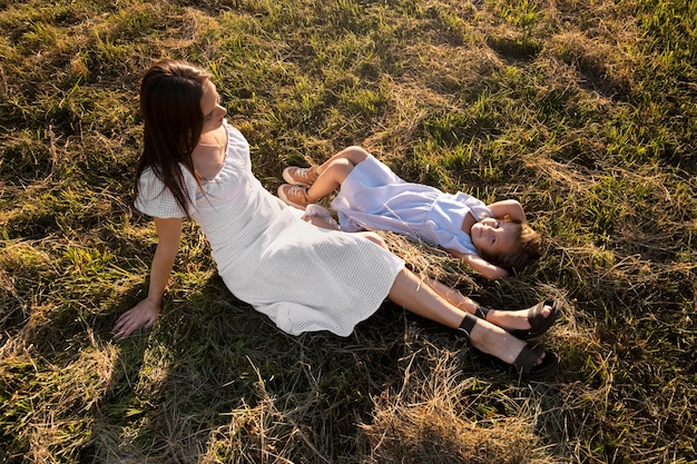 Mujer y niña de alto ángulo en el suelo