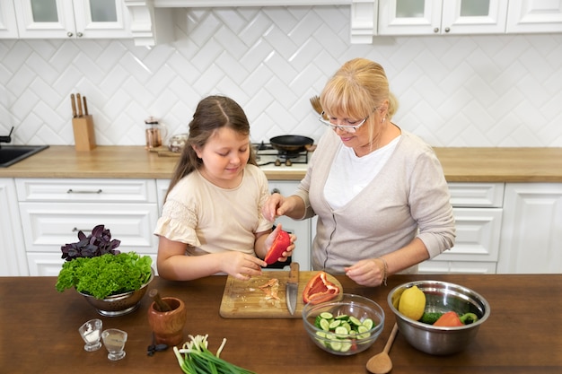 Mujer y niña cocinando juntos tiro medio