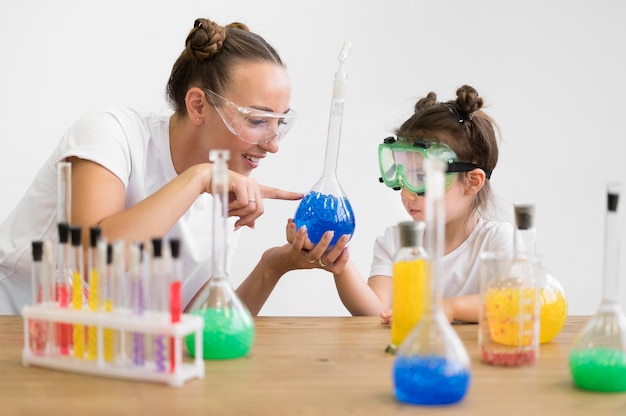 Mujer y niña con gafas de seguridad en laboratorio