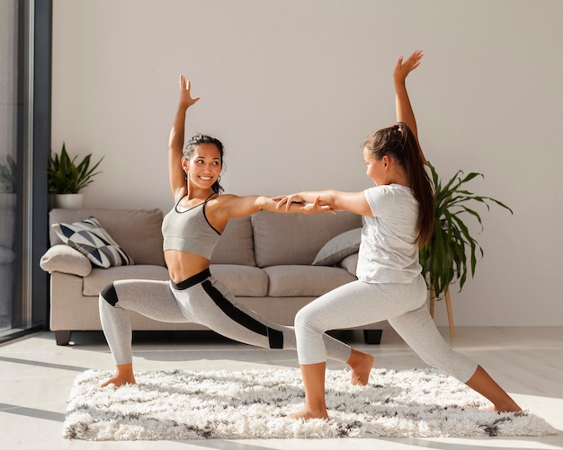 Mujer y niña haciendo deporte juntos en el interior