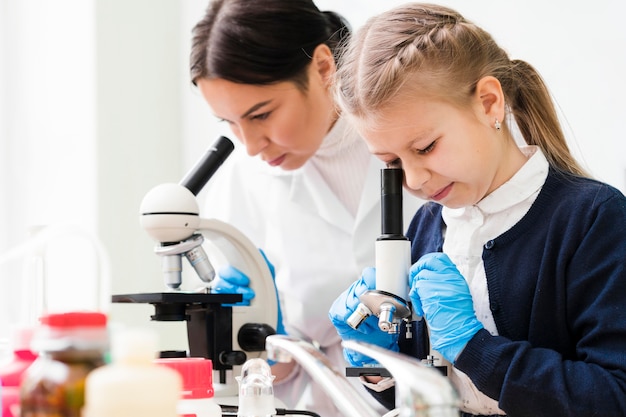 Mujer y niña con microscopios