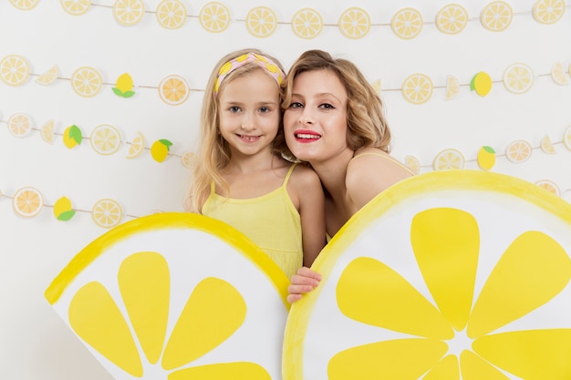 Foto gratuita mujer y niña posando con decoración de limón