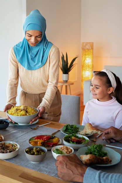 Foto gratuita mujer y niña sonriente de tiro medio con comida