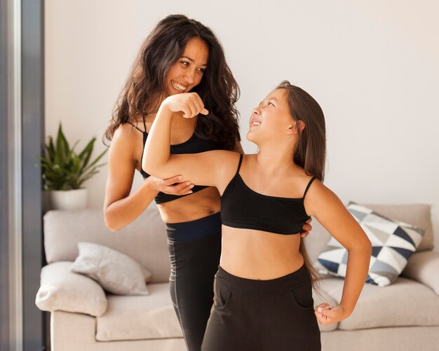 Mujer y niña sonriente de tiro medio