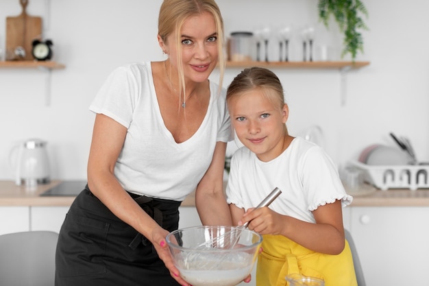 Mujer y niña sonriente de tiro medio