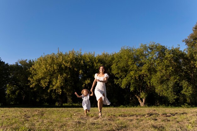 Mujer y niña de tiro completo al aire libre