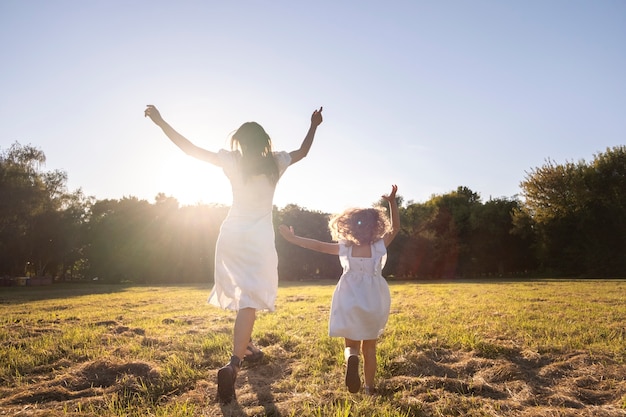 Mujer y niña de tiro completo al aire libre