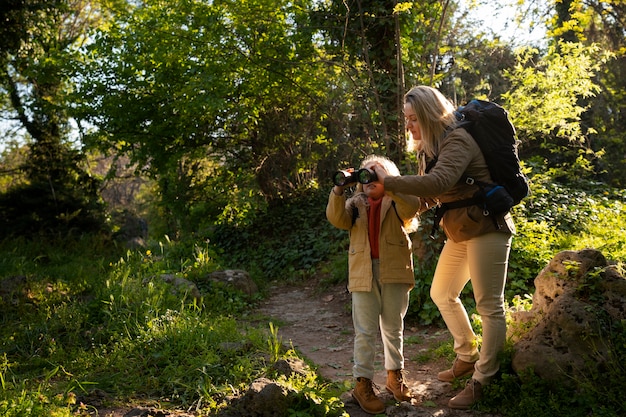 Mujer y niña de tiro completo explorando la naturaleza.