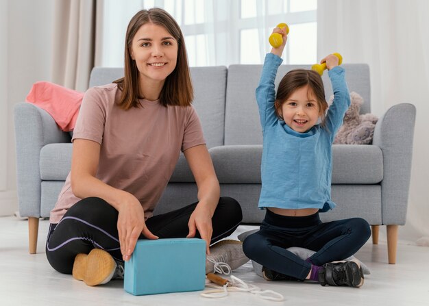 Mujer y niña de tiro completo en el interior