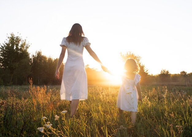 Mujer y niña de tiro completo en la naturaleza.