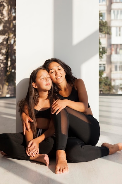 Foto gratuita mujer y niña de tiro completo sentados juntos