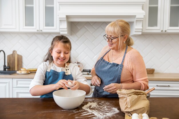 Foto gratuita mujer y niña de tiro medio cocinando