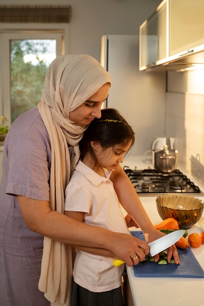 Mujer y niña de tiro medio cocinando