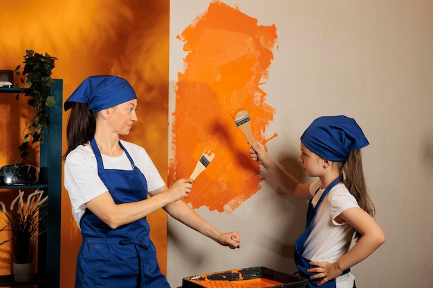 Mujer con niña usando pintura naranja