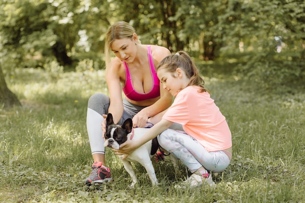 Mujer y niña van a pasear con su perro en el parque