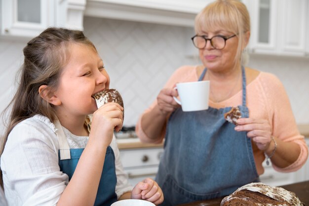 Mujer y niño comiendo pan de tiro medio