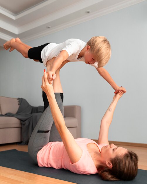 Mujer y niño haciendo yoga full shot