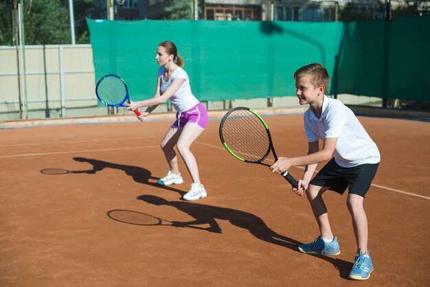 Mujer y niño jugando al tenis