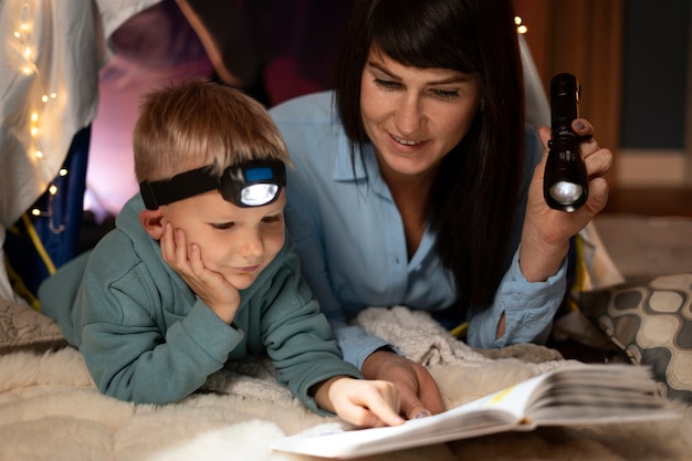 Mujer y niño leyendo juntos plano medio