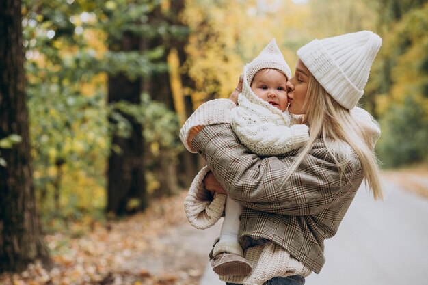 Mujer con niño pequeño en el parque otoño