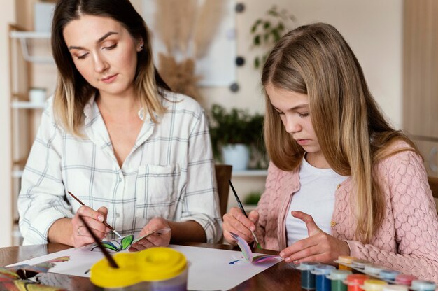 Mujer y niño pintando mariposas