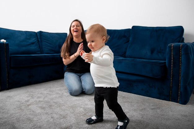 Mujer y niño sonrientes de tiro completo en casa